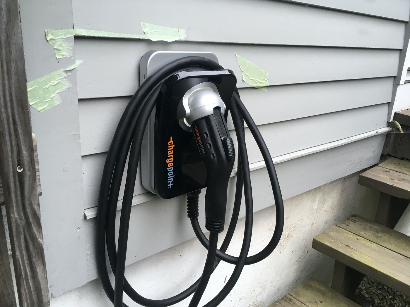 Home EV charger mounted on the siding of a house